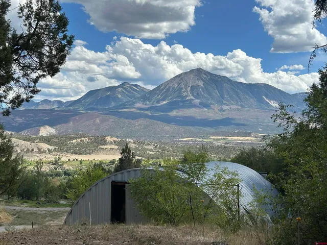 a living room with furniture a ceiling fan and a large window