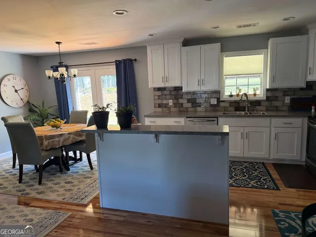 a kitchen with sink a table and chairs in it