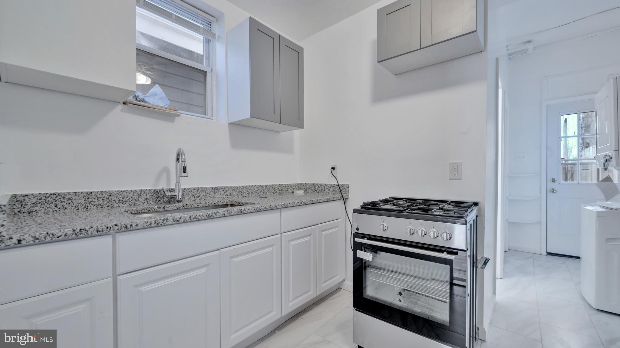 1528 E Street Southeast Washington, DC 20003 - Photo 7 of 19 a kitchen with granite countertop a stove sink and cabinets