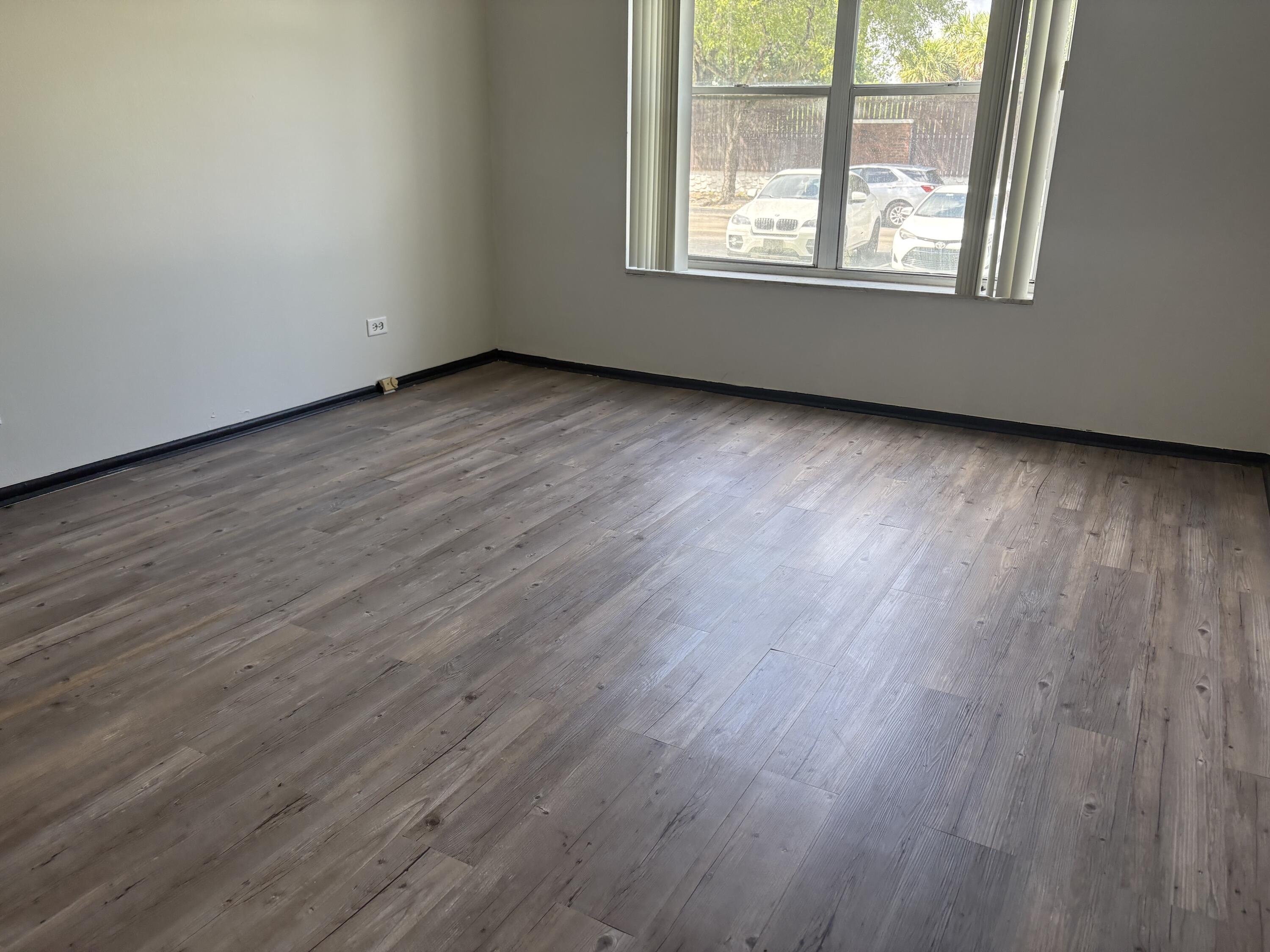 3660 Inverrary Drive, Unit 1B Lauderhill, FL 33319 - Photo 24 of 27 an empty room with wooden floor and windows