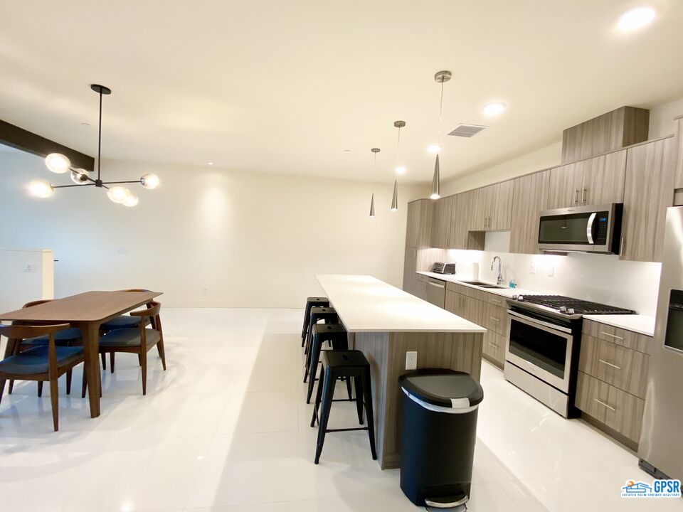 158 The River Palm Springs, CA 92262 - Photo 3 of 17 a kitchen with kitchen island a stove a table and chairs