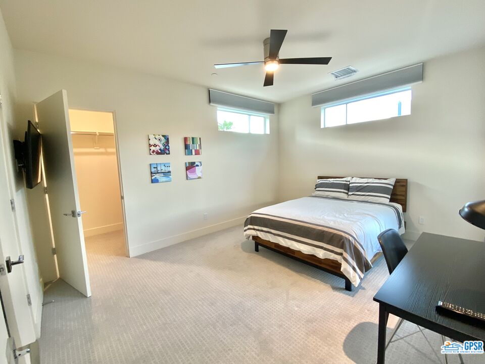 158 The River Palm Springs, CA 92262 - Photo 9 of 17 a bedroom with a bed and a chandelier
