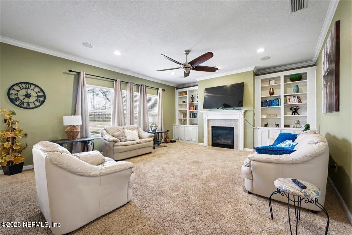 8131 Broward Cove Road Jacksonville, FL 32218 - Photo 17 of 35 a living room with furniture a fireplace and a flat screen tv