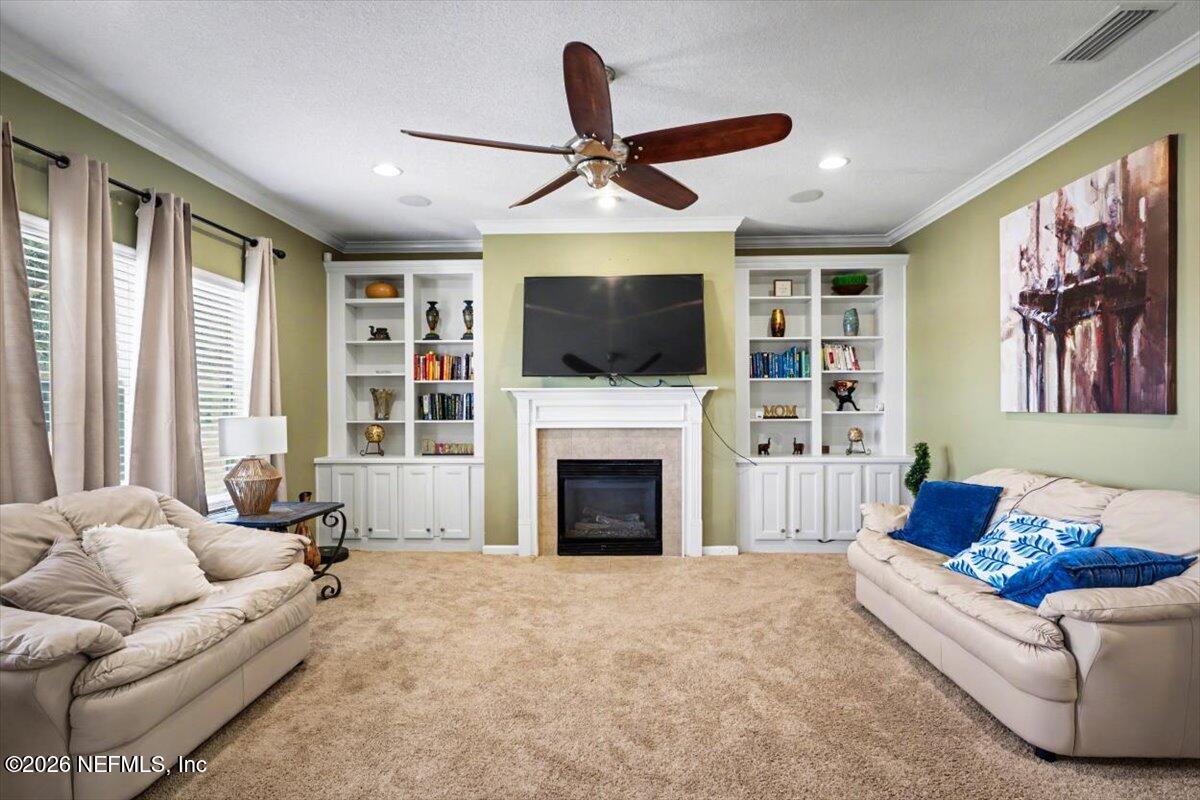 8131 Broward Cove Road Jacksonville, FL 32218 - Photo 18 of 35 a living room with furniture a flat screen tv and a fireplace