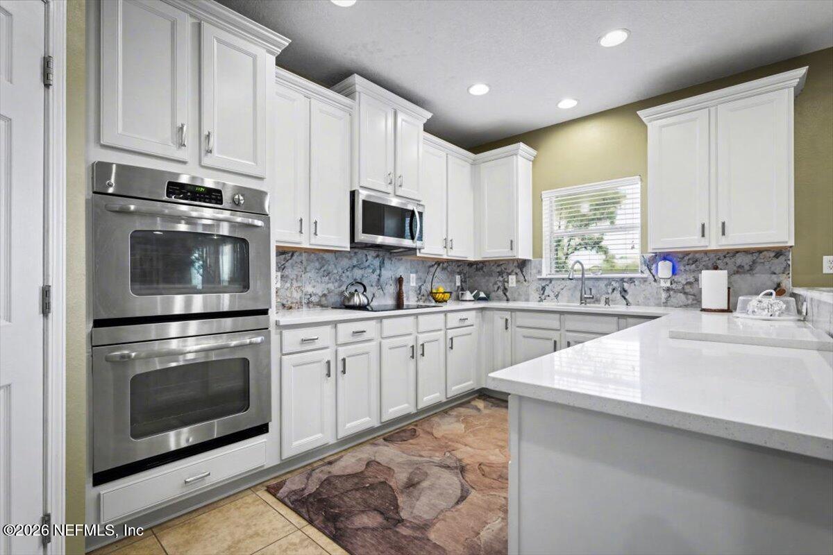 8131 Broward Cove Road Jacksonville, FL 32218 - Photo 22 of 35 a kitchen with stainless steel appliances granite countertop a stove a sink and a microwave