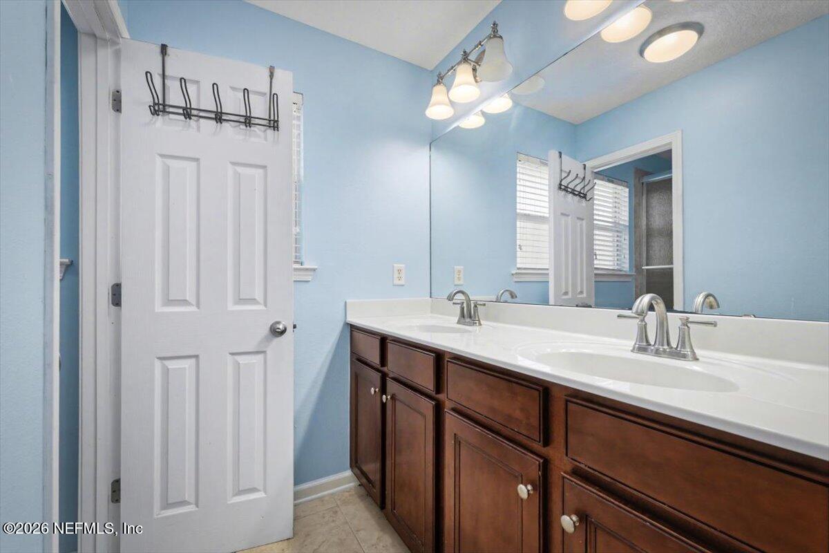 8131 Broward Cove Road Jacksonville, FL 32218 - Photo 25 of 35 a bathroom with a double vanity sink a vanity and a mirror