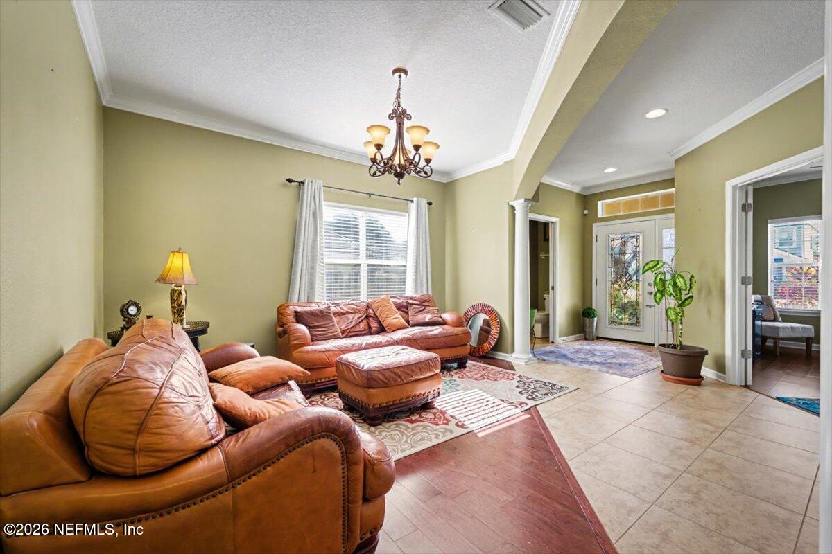 8131 Broward Cove Road Jacksonville, FL 32218 - Photo 3 of 35 a living room with furniture and a chandelier
