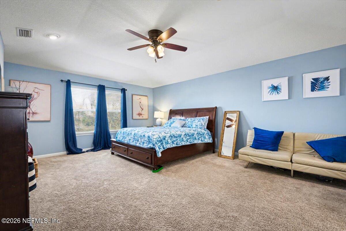 8131 Broward Cove Road Jacksonville, FL 32218 - Photo 33 of 35 a bedroom with a bed and a chandelier