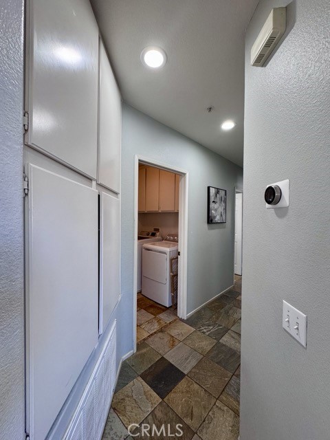 33423 Winston Way, Unit C Temecula, CA 92592 - Photo 22 of 39 a view of a hallway with a refrigerator and wooden floor