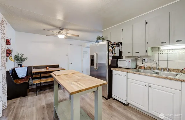 a kitchen with stainless steel appliances kitchen island a refrigerator sink and cabinets