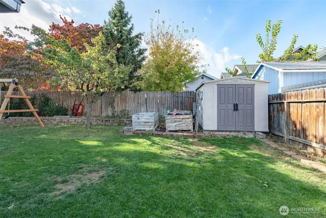 a view of a backyard with a small cabin and wooden fence