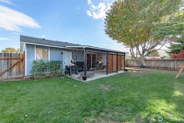 a view of a house with backyard and sitting area