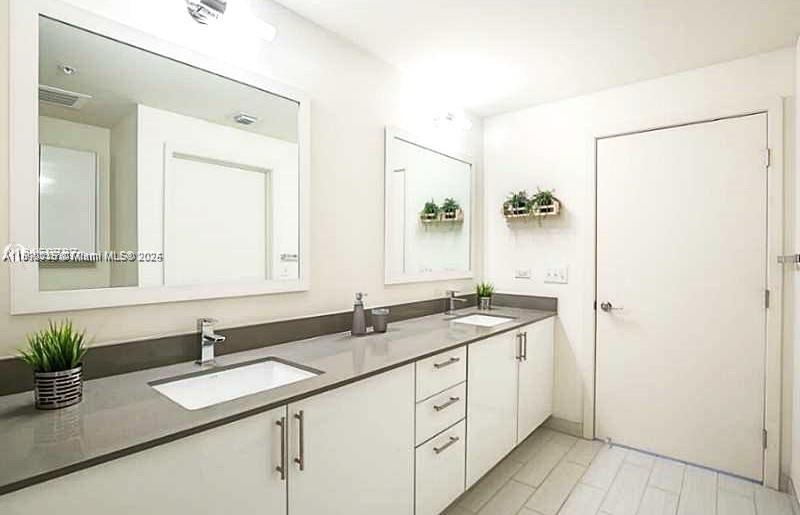 999 Southwest 1st Avenue, Unit 2115 Miami, FL 33130 - Photo 13 of 27 a bathroom with a sink and a mirror