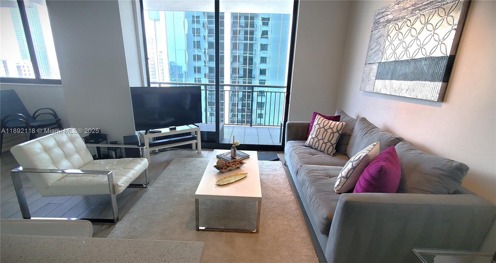 999 Southwest 1st Avenue, Unit 2115 Miami, FL 33130 - Photo 4 of 27 a living room with furniture and a flat screen tv