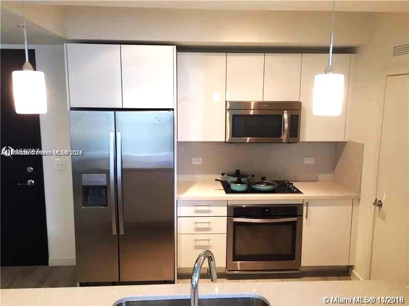 999 Southwest 1st Avenue, Unit 2115 Miami, FL 33130 - Photo 10 of 27 a kitchen with a refrigerator and a stove