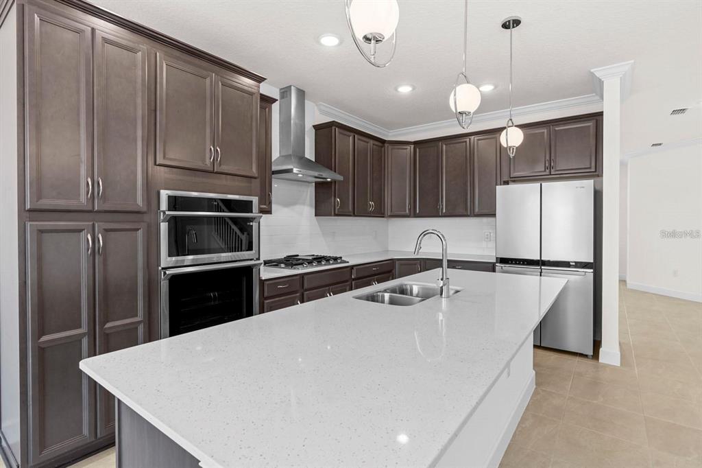 933 Signet Drive Apollo Beach, FL 33572 - Photo 6 of 66 a kitchen with stainless steel appliances a refrigerator a sink a stove a microwave and island