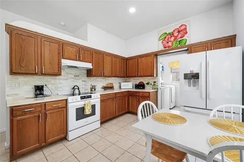 a kitchen with stainless steel appliances granite countertop a kitchen island a stove a sink dishwasher and cabinets with wooden floor