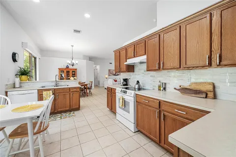 a kitchen with stainless steel appliances kitchen island granite countertop a sink a stove counter space and cabinets