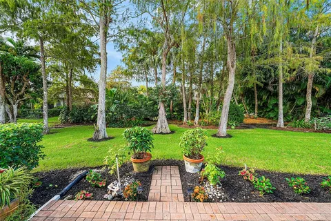 a view of backyard with seating space and trees