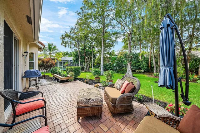 a view of a patio with couches chairs and a yard
