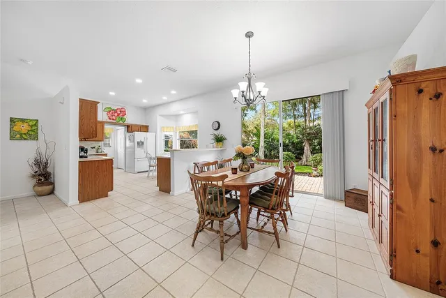 a view of a dining room and livingroom with furniture wooden floor a chandelier