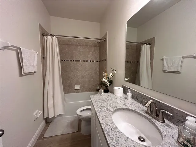 a bathroom with a granite countertop sink a mirror and shower