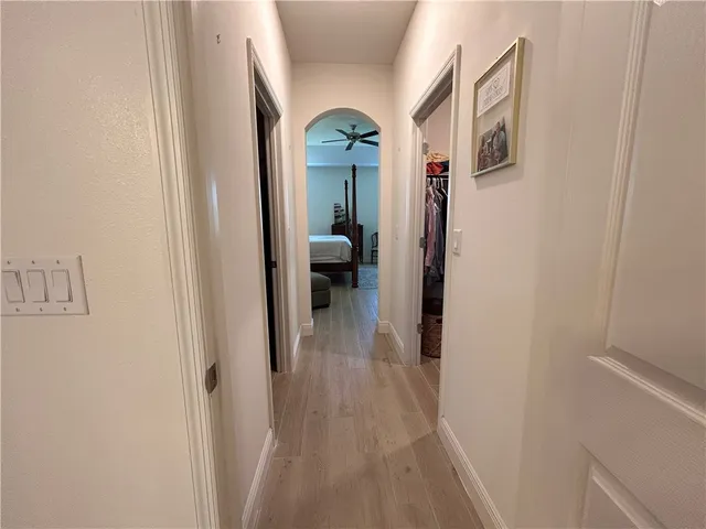 a view of a hallway with wooden floor and a livingroom