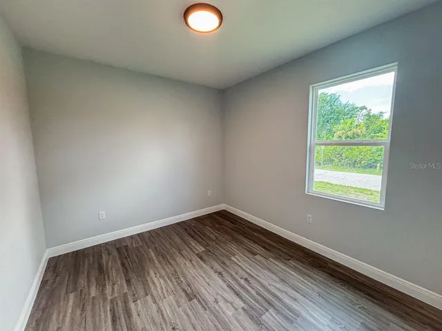 a view of a room with wooden floor and window