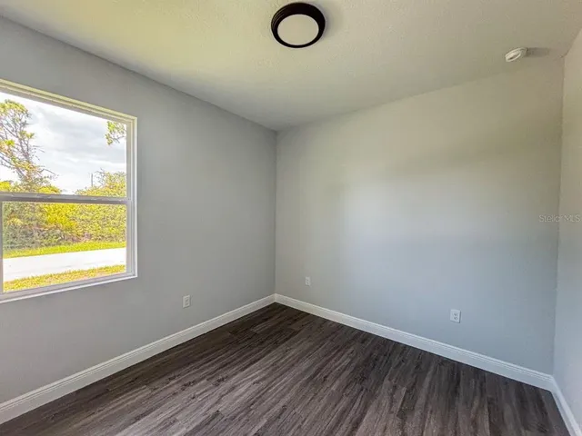 a view of a room that has wooden floor and cabinets