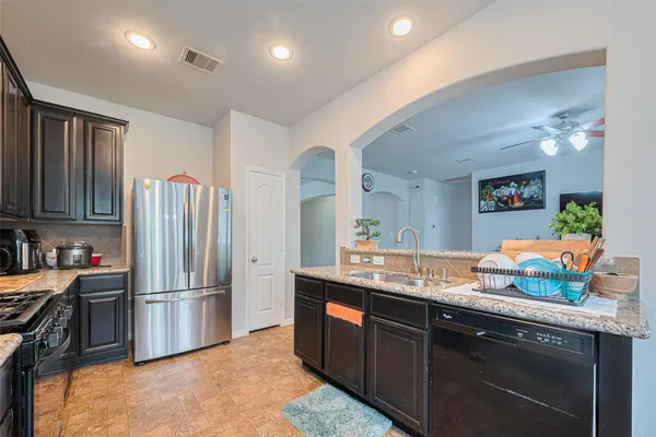 a kitchen with granite countertop a refrigerator and a sink