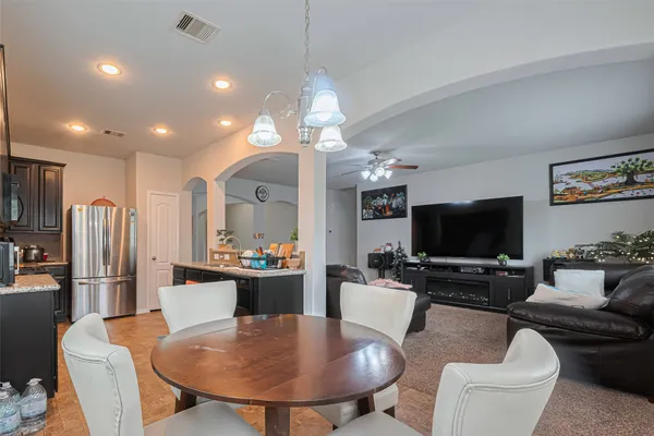 a living room with furniture a flat screen tv and kitchen view