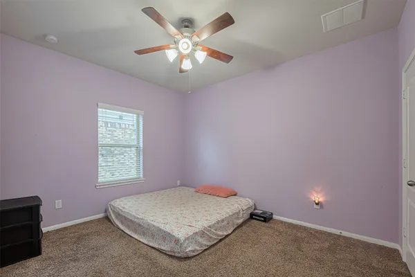 a spacious bedroom with a bed and a chandelier