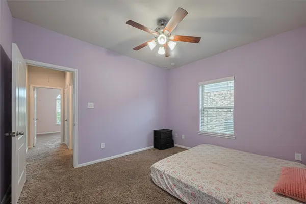 a bedroom with a large bed chandelier and a window