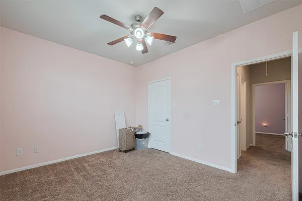 an empty room with fan and entrance
