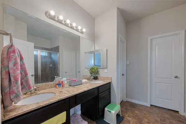 a bathroom with a double vanity sink and a mirror