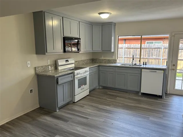 a kitchen with stainless steel appliances granite countertop a sink stove and wooden floor