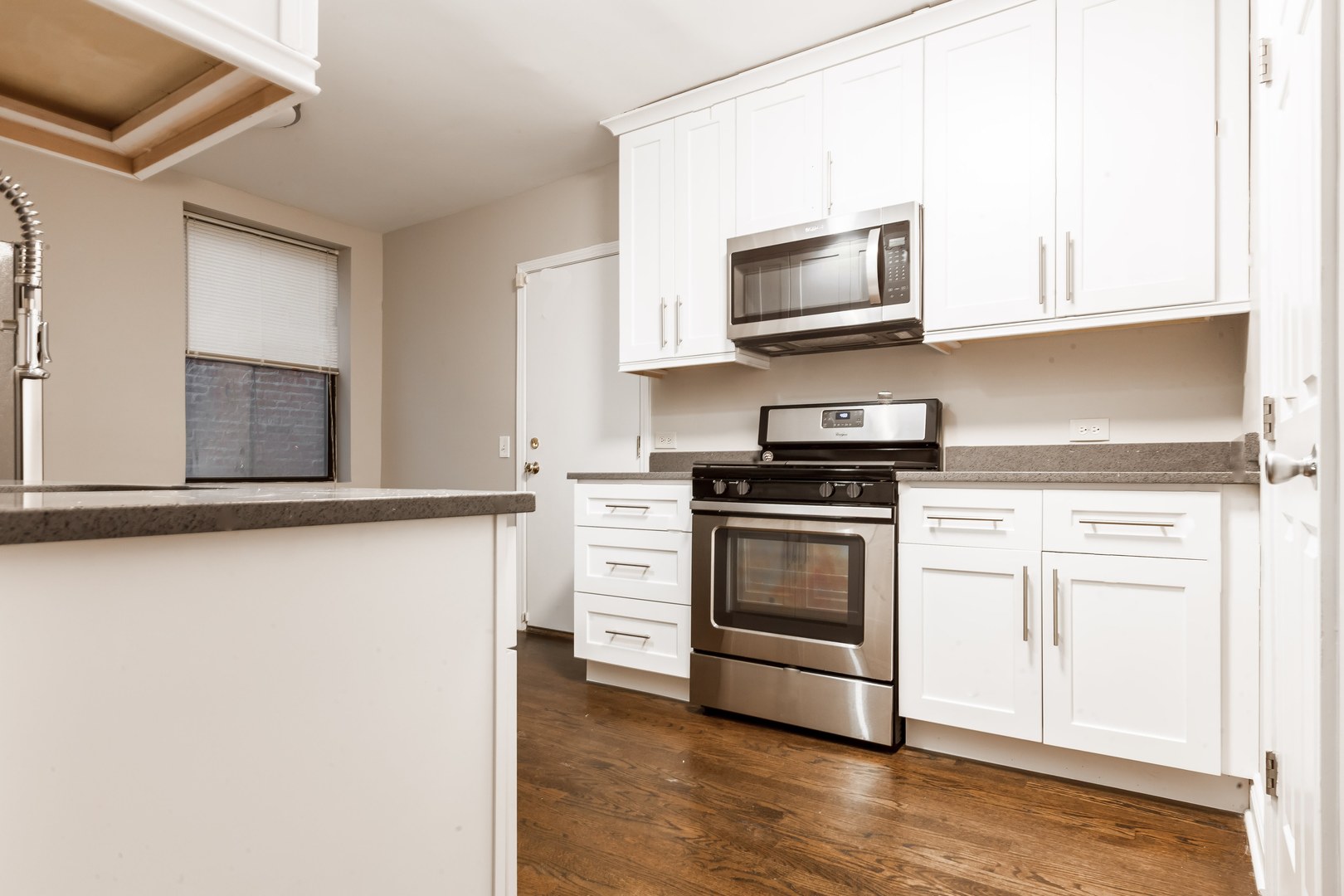 4529.5 South Drexel Boulevard, Unit 2W Chicago, IL 60653 - Photo 6 of 11 a kitchen with stainless steel appliances white cabinets and a stove top oven