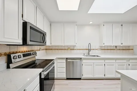a kitchen with a sink stove top oven and cabinets