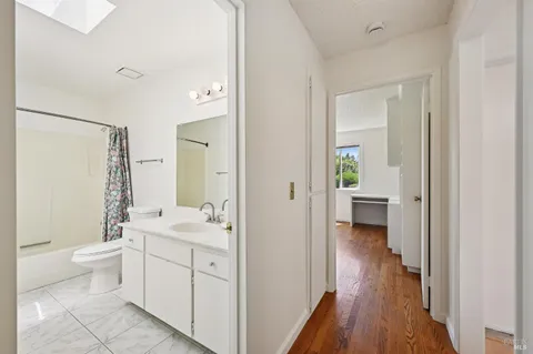 a view of a kitchen with wooden floor and a window