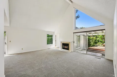 a view of an empty room with a fireplace and a window