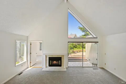 a view of an empty room with a fireplace and a window