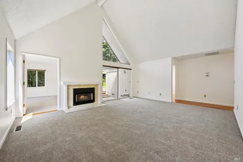 a view of an empty room with window and closet area