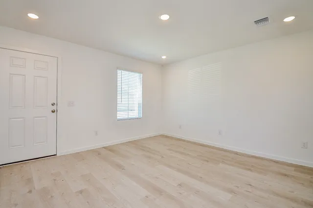 wooden floor in an empty room with a window