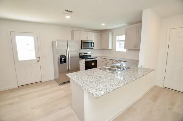 a kitchen with stainless steel appliances granite countertop a sink refrigerator and microwave