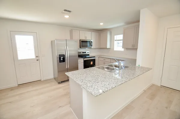 a kitchen with stainless steel appliances granite countertop a sink refrigerator and microwave