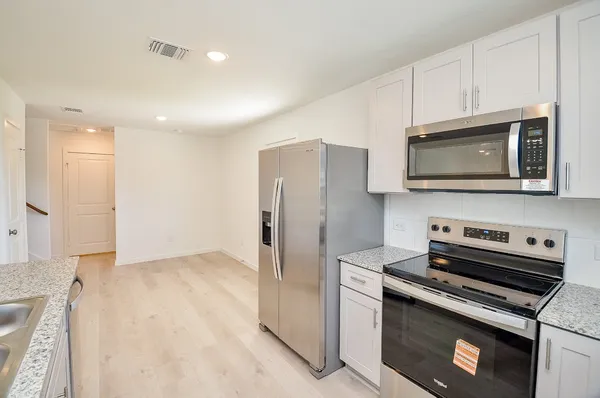a kitchen with stainless steel appliances a stove a microwave and a refrigerator