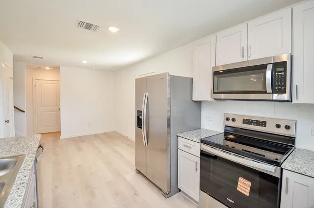 a kitchen with stainless steel appliances a stove a microwave and a refrigerator