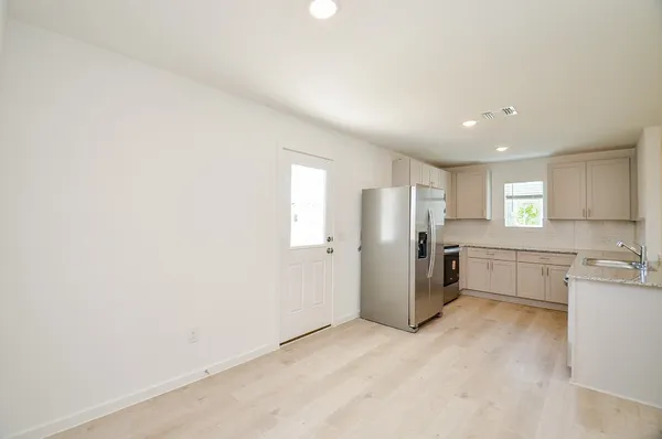 a view of a kitchen with refrigerator and windows