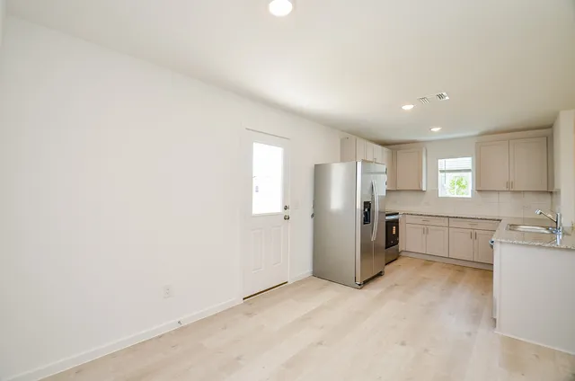 a view of a kitchen with refrigerator and windows