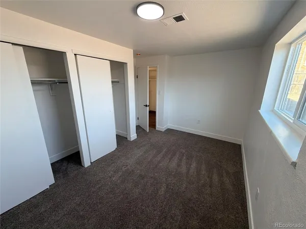 an empty room with windows and closet